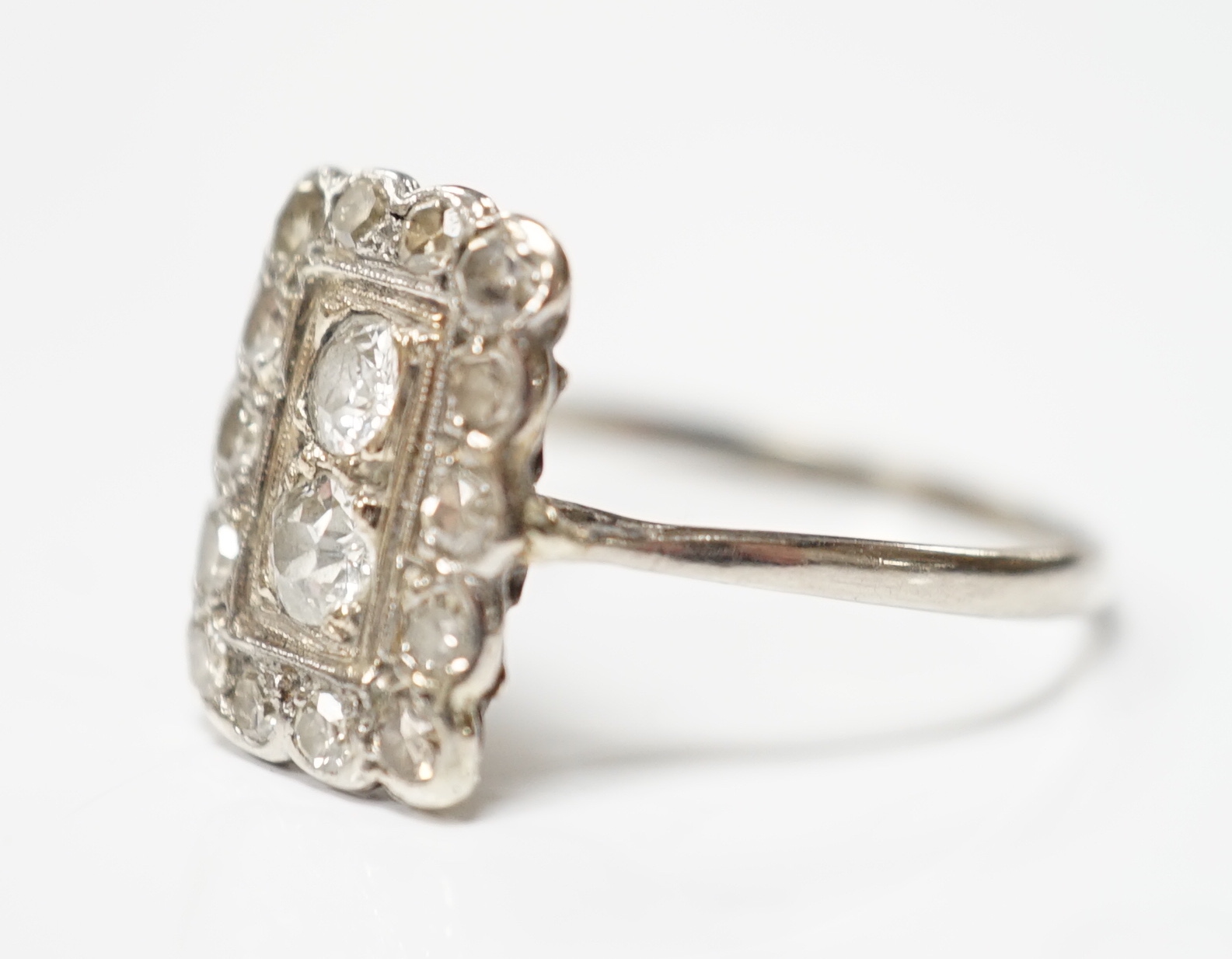 An early 20th century white metal and diamond cluster set tablet ring, size P/Q, gross weight 2.2 grams.